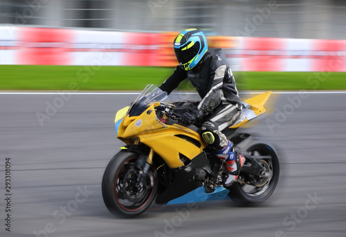 Motorcycle rider racing at high speed on race track © Alexey Kuznetsov