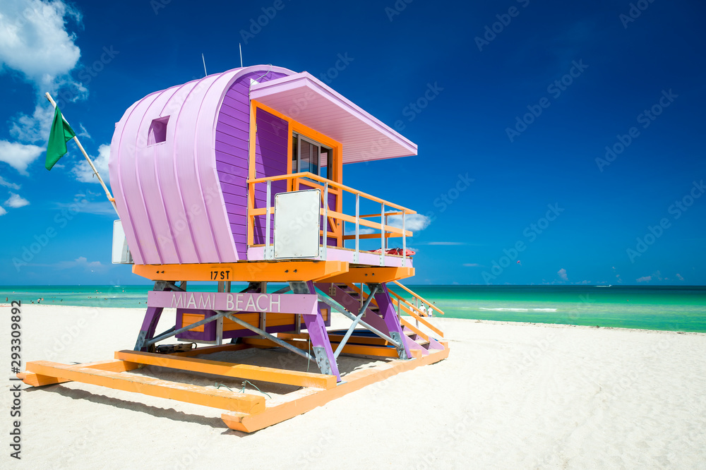 Fototapeta premium Wibrujący słoneczny widok wieży ratownika pomalowany w pastelowych kolorach pod jasnym błękitnym niebem w South Beach w Miami na Florydzie