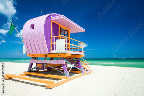 Vibrant sunny view of lifeguard tower painted pastel colors under bright blue sky on South Beach, Miami, Florida