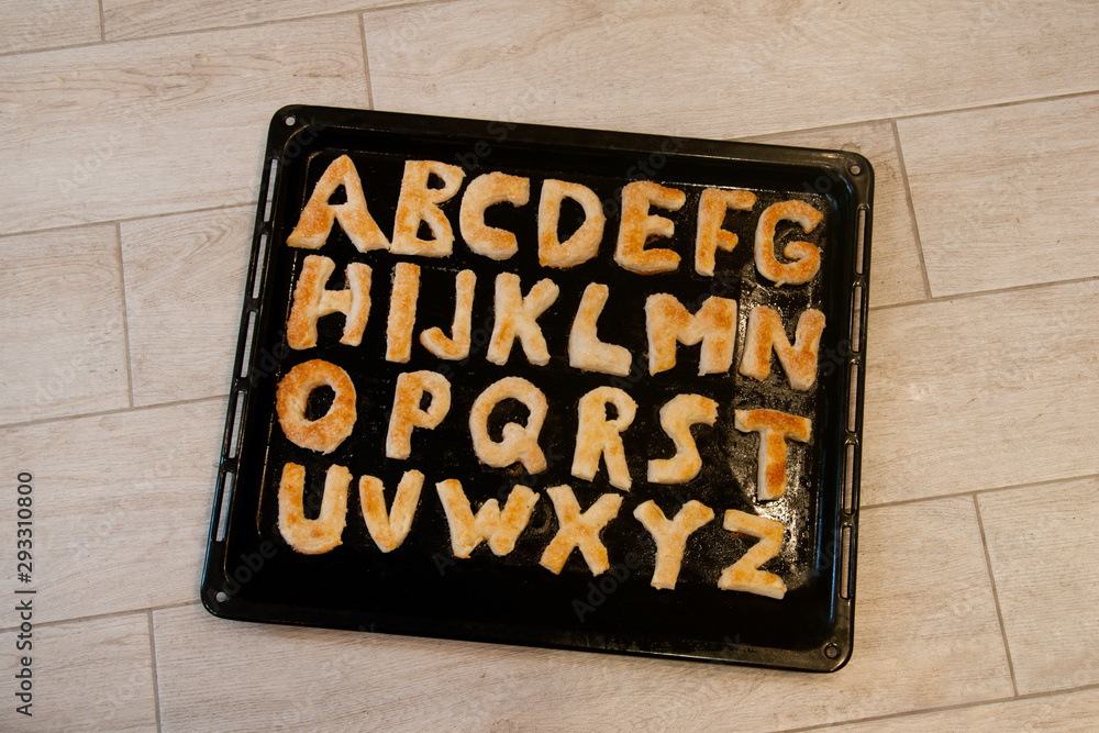 Puff pastry in the oven. English alphabet from the test. Edible letters  Stock Photo