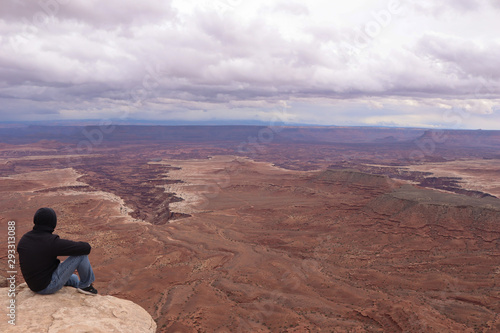 Man Overlooks Canyon on a Cloudy Day
