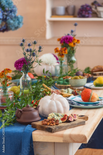 Food and autumn paraphernalia, pumpkins, flowers on the festively served autumn table