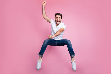 Full length photo of crazy active middle eastern guy cowboy concept ride fast derby horse on prairie jump scream shout feel rejoice wear stylish trendy clothes sneakers isolated pink color background