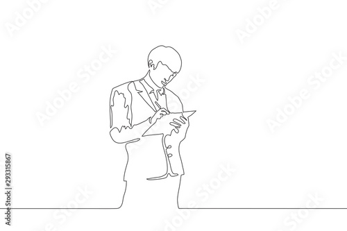 Continuous one line art a young man holds a folder with his left hand and writes with a pen on it with his right hand. Line sketch of businessman in a suit on a white background. Black stroke drawing