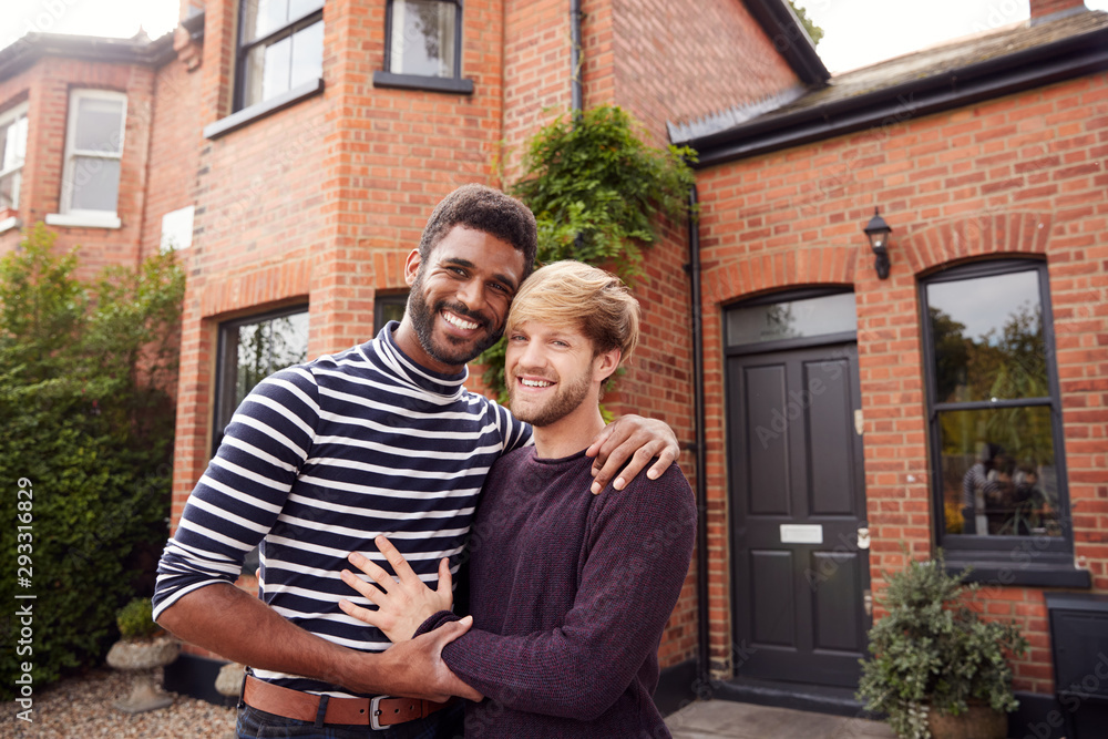 Fototapeta premium Portrait Of Excited Gay Male Couple Standing Outside New Home On Moving Day Together