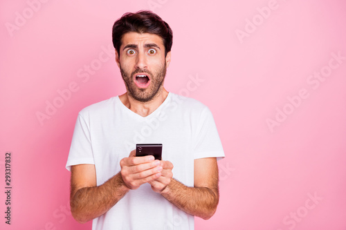 Portrait of negative addicted shocked funky middle eastern man hold use smartphone read got notification dislike scream omg unbelievable expression wear style clothes isolated pastel color background © deagreez