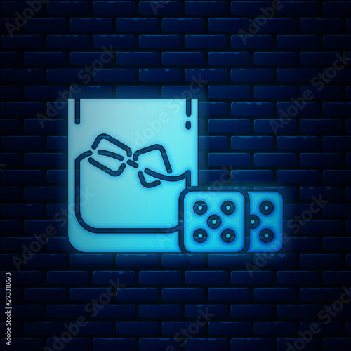 Glowing neon Game dice and glass of whiskey with ice cubes icon isolated on brick wall background. Casino gambling. Vector Illustration