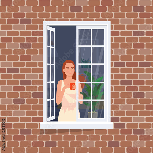 Beautiful girl in the window with flying hair from the breeze.