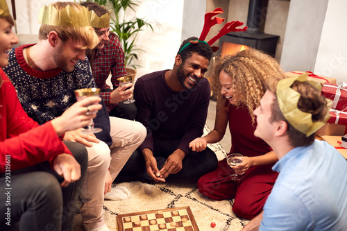 Group Of Friends Playing Board Games After Enjoying Christmas Dinner At Home photo