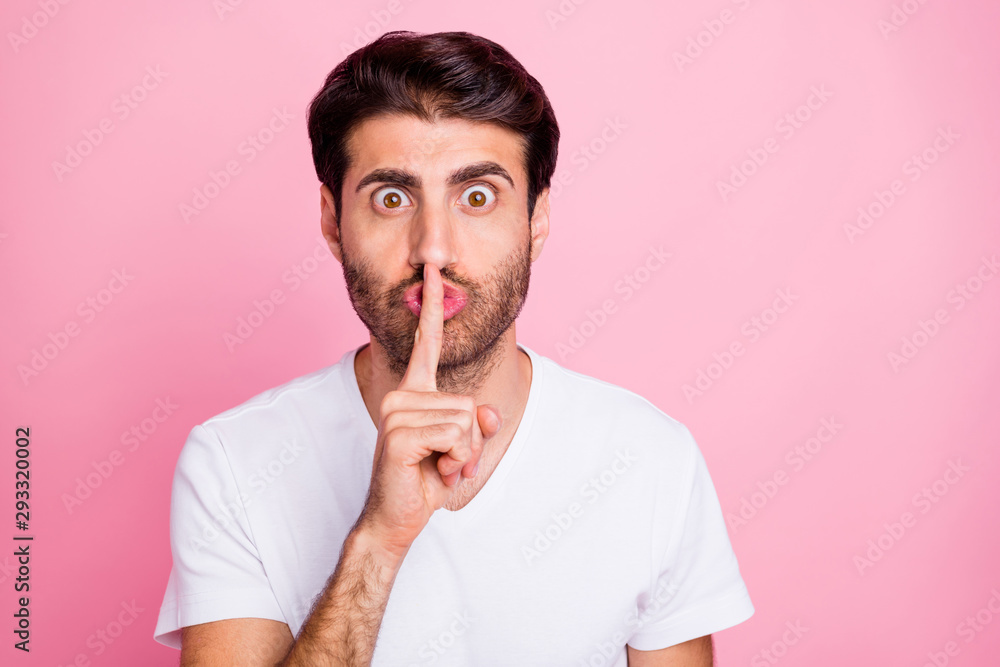 Portrait of irritated funny funky middle eastern man show index finger mite symbol say keep secret it is confidetiality wear style white clothes isolated over pink color background Stock Photo | Adobe