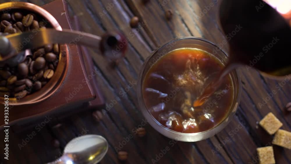Freshly brewed coffee from cezve is poured into a coffee cup. Steam comes out of the cup, an old coffee grinder is in the composition. 4K video. Freshly brewed coffee from cezve is poured into a coffee cup. Steam comes out of the cup, an old coffee grinder is in the composition. 4K video.