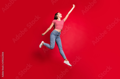 Full length body size photo of ecstatic stylish trendy beautiful charming cute lady trying to catch something while stretching isolated with red background