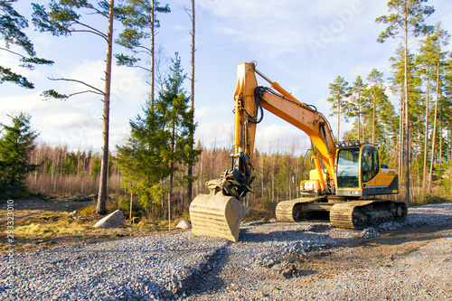 Yellow excavator building a road deep in the forest. Rusko, Finland. photo
