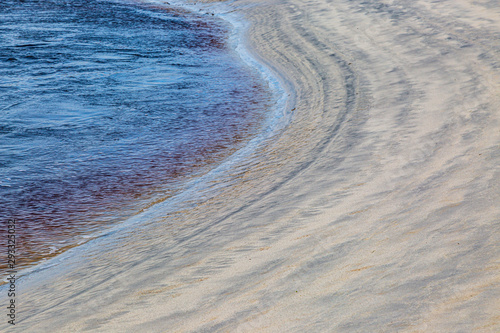 A full frame photograph of the water's edge and patterns in the sand photo