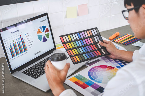 Young creative graphic designer working on project architectural drawing and color swatches, selection coloring on graphic chart with work tools and equipment photo