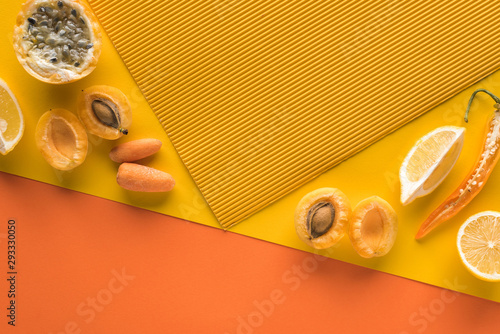 top view of fresh fruits and vegetables on yellow and orange background with copy space photo