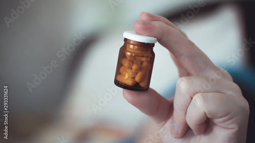 Wallpaper Mural Small brown glass bottle with antibiotic pills in a female hand Torontodigital.ca