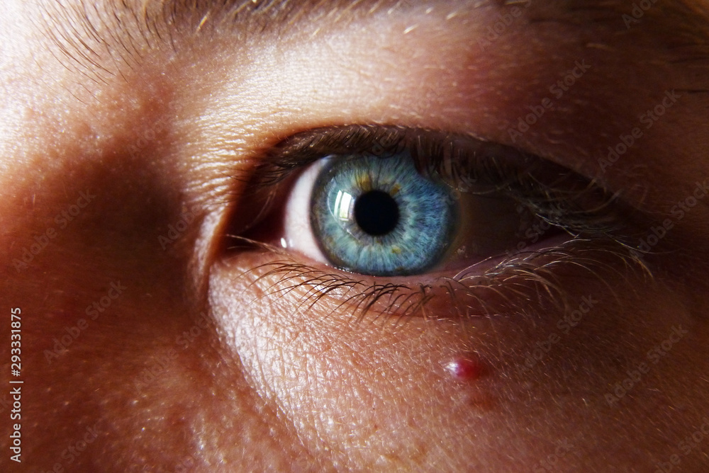 Fototapeta premium Deep blue eye watching into the abyss, blond haired