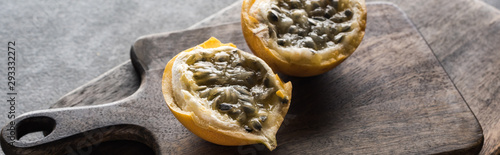 sweet granadilla on wooden cutting boards on grey background, panoramic shot photo