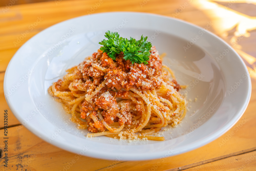 Closeup photo of spaghetti topped with parsley on white plate Closeup photo of spaghetti topped with parsley on white plate