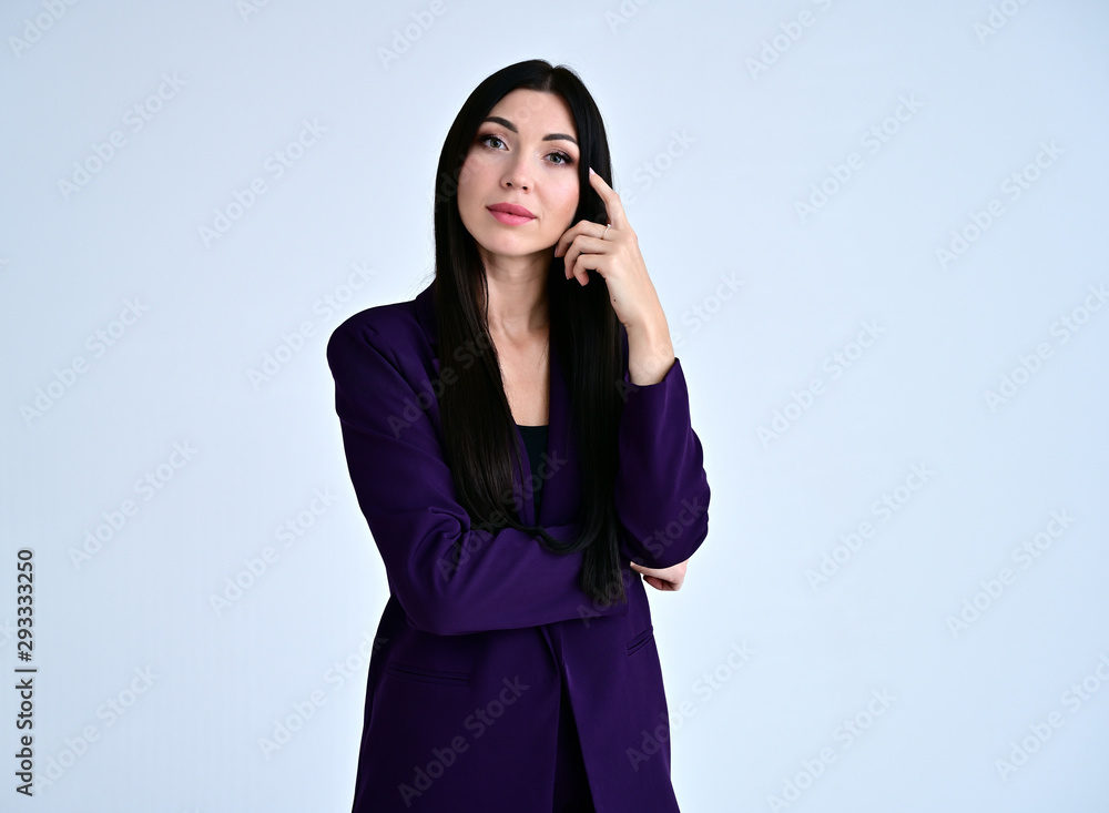 Portrait of a pretty brunette girl with good makeup with long hair on a white background in a dark business suit. Stands in different poses with emotions. Portrait of a pretty brunette girl with good makeup with long hair on a white background in a dark business suit. Stands in different poses with emotions.