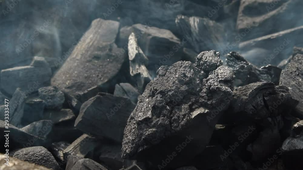 Burning black coal emitting smoke sprinkled in the grill and glowing for the barbecue. Burning black coal emitting smoke sprinkled in the grill and glowing for the barbecue.