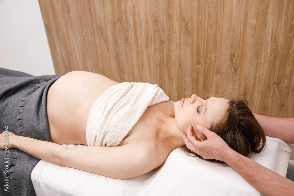 Pregnant woman receiving osteopathic treatment of her head Pregnant woman receiving osteopathic treatment of her head