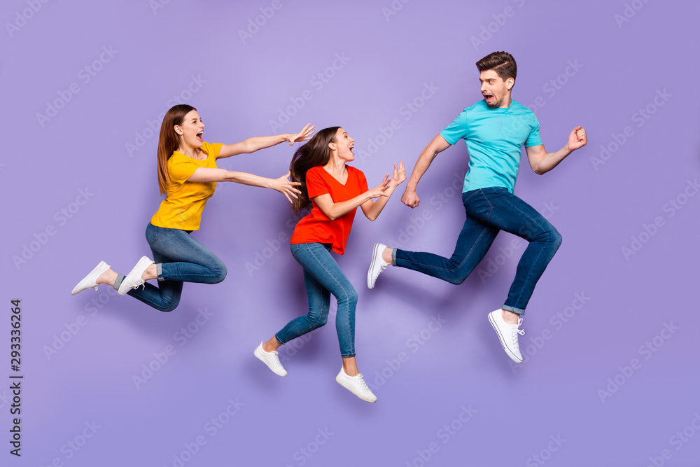 Full length side profile view photo of one unhappy shocked hipster running away from two wild mad want to catch him ladies isolated violet background Full length side profile view photo of one unhappy shocked hipster running away from two wild mad want to catch him ladies isolated violet background