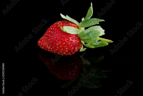 A single strawberry isolated on black background