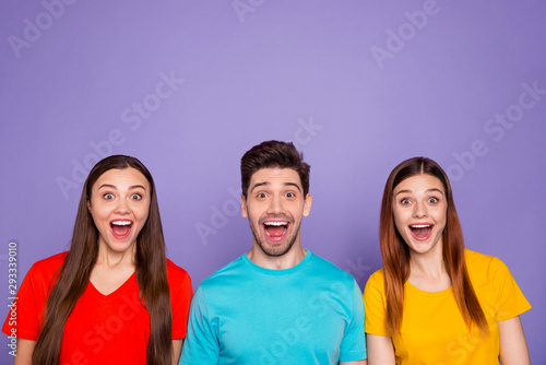 Portrait of nice attractive lovely charming cute cheerful cheery glad guys wearing colorful t-shirts good news amazement expression isolated over violet lilac background