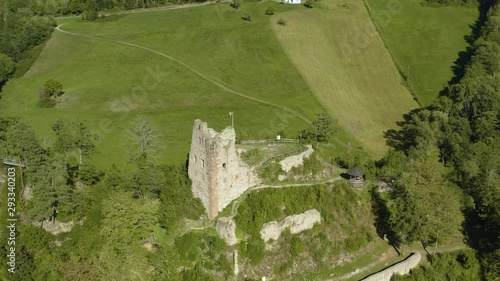 Aerial view of the castle Schenkenburg close to Schenkenzell in Germany in the black forest on a sunny day in summer. Pan to the right beside the castle with the village in the back. photo