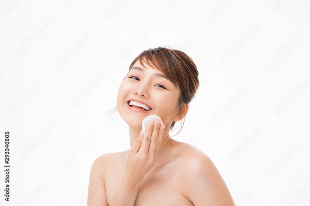 Asian woman with fair perfect healthy glow skin hands hold cotton pad cleansing face isolated on white Asian woman with fair perfect healthy glow skin hands hold cotton pad cleansing face isolated on white