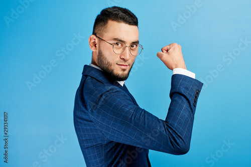 Photos Kazakh Asian businessman in suit and glasses shows biceps, demonstrates his stre