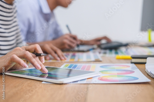 Two colleagues creative graphic designer working on color selection and drawing on graphics tablet at workplace, Color swatch samples chart for selection coloring