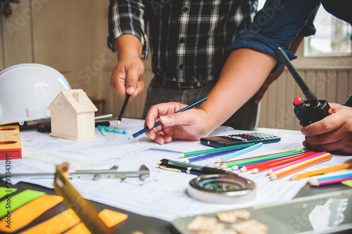 Engineers and architects are looking at construction plans and ordering work for contractors through radio communications.