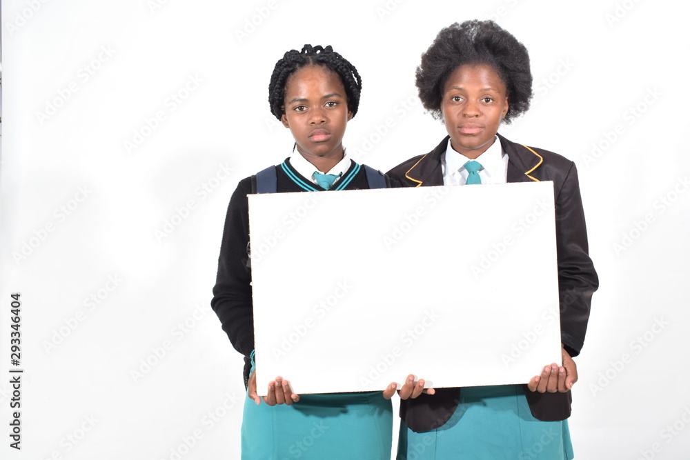 happy beautiful school girls with backpack isolated on white background holding a white board happy beautiful school girls with backpack isolated on white background holding a white board