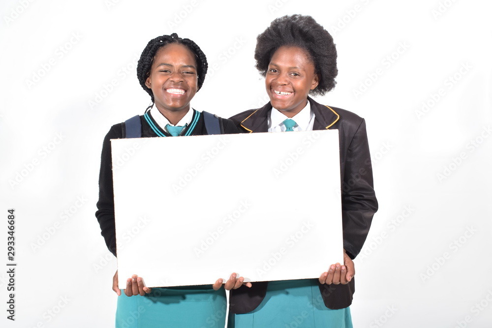 happy beautiful school girls with backpack isolated on white background holding a white board happy beautiful school girls with backpack isolated on white background holding a white board