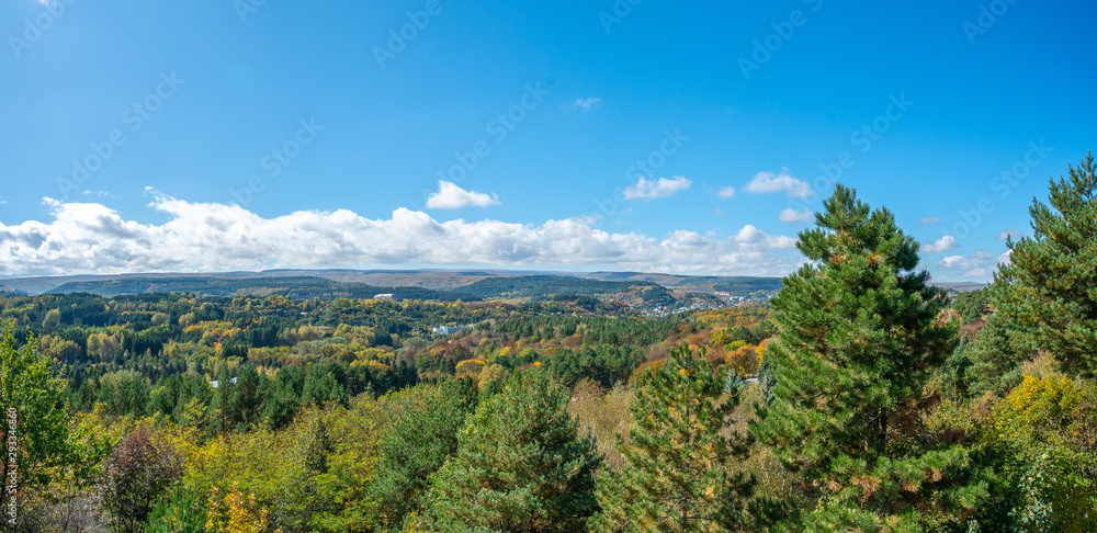 Autumn landscape: Kislovodsk resort park from above, tops of colorful trees, mountains and sky