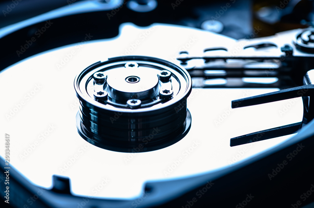 The abstract image of inside of hard disk drive on the technician's desk. the concept of data, hardware, and information technology. The abstract image of inside of hard disk drive on the technician's desk. the concept of data, hardware, and information technology.