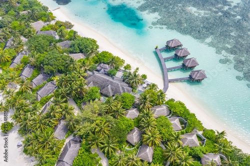 Amazing aerial Maldives island beach. Tropical view of palm trees and water villas. Luxury summer travel landscape