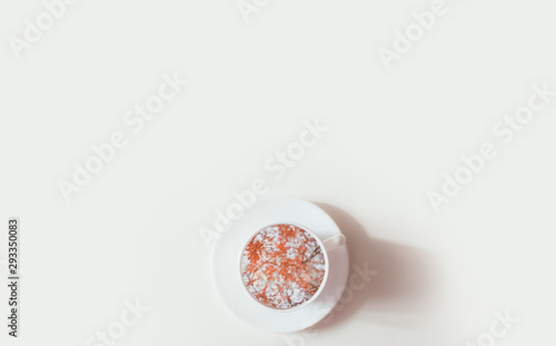 Bright orange leaves in a cup on white background. Flat lay. Place for text.
