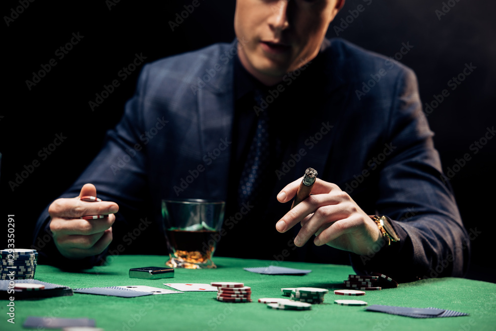 cropped view of man holding cigar isolated on black cropped view of man holding cigar isolated on black