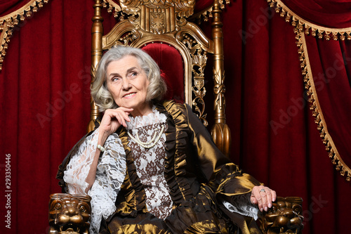 Portrait of beautiful senior queen on throne