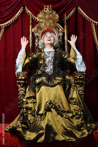 Portrait of happy beautiful senior queen on throne
