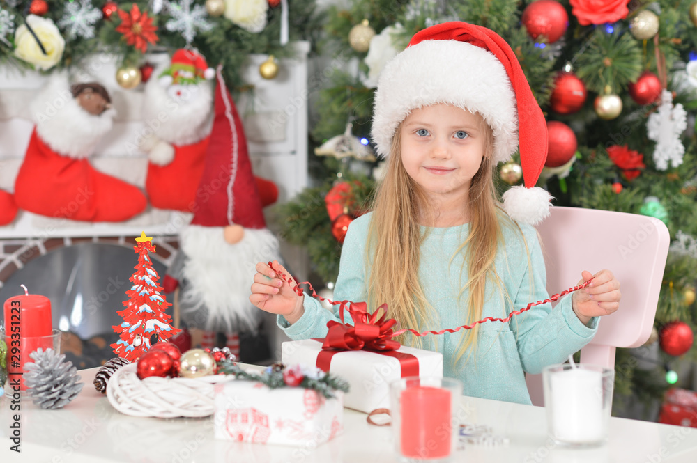 Cute little girl with New Year's gifts in Santa's hat Cute little girl with New Year's gifts in Santa's hat