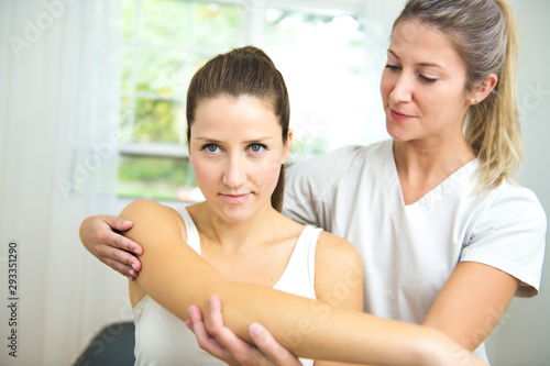 A Modern rehabilitation physiotherapist at work with client. working on shoulder.