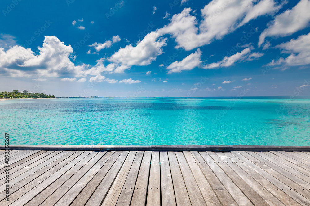 Empty wooden planks with blur beach on background, can be used for product placement, palm leaves on foreground