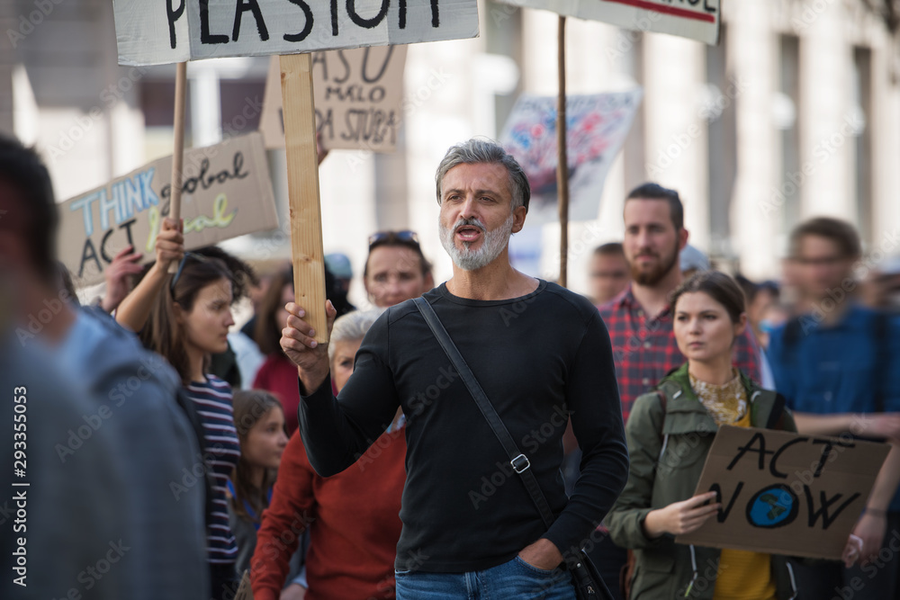 Obraz premium People with placards and protective suit on global strike for climate change.