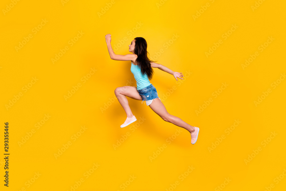 Full length body size photo of side profile sports woman in urgency running after sales and discounted goods wearing jeans denim shorts sportive sneakers isolated vibrant color background