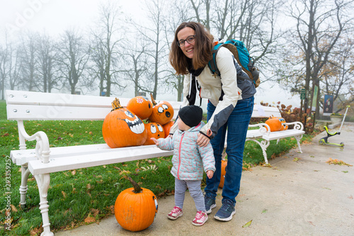 Mother and daughter exploring many pumpinks with faces. photo